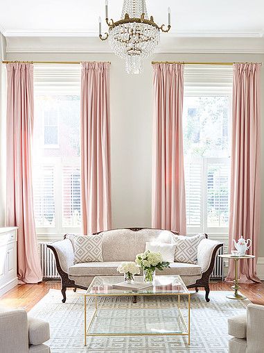 Pink draperies providing a background to an antique chair in a lounge room setting